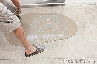 Repair work. Pouring floors in the room. Fill screed floor repair and furnish. Worker pouring concrete on the floor Stock Photo