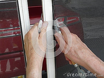 Repairing Screen Door with Spline Tool Stock Photo