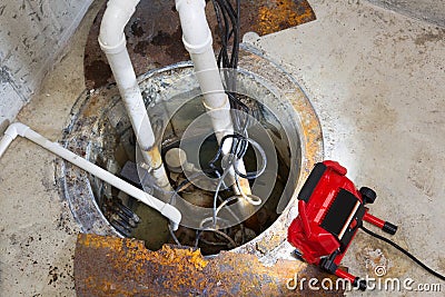 Repairing a sump pump in a basement Stock Photo