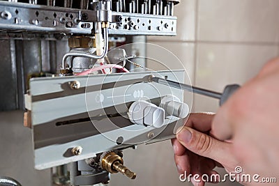 Repairman adjusting gas water heater Stock Photo