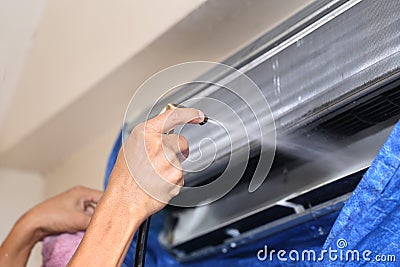 Repairman fixing and cleaning air conditioner unit Stock Photo