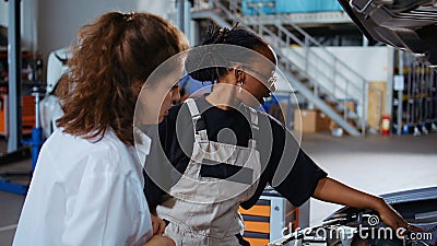 Repairman in garage fixes customers car Stock Photo