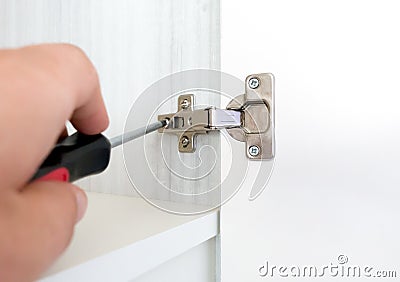 Repairman install cabinet hinge Stock Photo