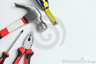 Repairman intruments hammer, screwdriver, measuring tape on white wooden background with copy space and top view Stock Photo