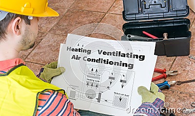 Repairman is looking at documentation of HVAC Stock Photo