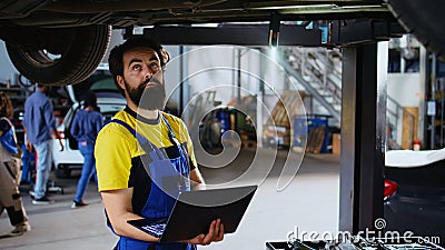 Repairman looks online for new car parts Stock Photo