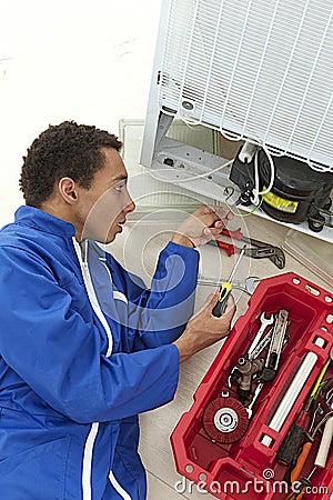 Repairman makes refrigerator appliance Stock Photo