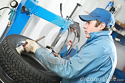 Repairman mechanic lubricating car tyre Stock Photo