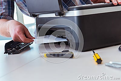 The repairman repairing broken color printer Stock Photo