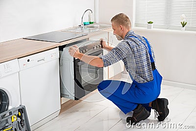 Repairman Repairing Oven Stock Photo