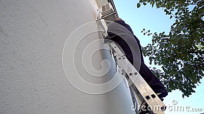 Repairman Works On Air Conditioner outdoor unit Stock Photo