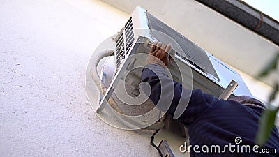 Repairman Works On Demontage of Air Conditioner outdoor unit Stock Photo