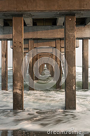 Repetition of the pilons, under a pier with long exposures Stock Photo