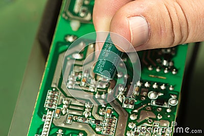 Replace capacitor in circuit board Stock Photo