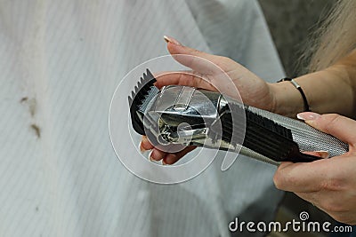 Replacing the nozzle of an electric hair clipper. Hands change nozzles electric hair clippers Stock Photo