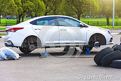 Replacing tires on wheels, a car without a wheels on a jack, express service maintenance Stock Photo