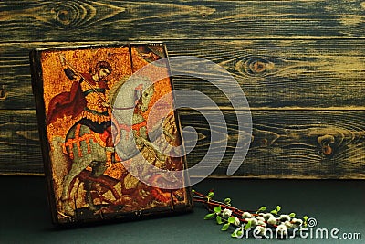 Icon of St. George the Victorious replica and willow and birch branches on dark wooden background. Symbolic concept â€” faith, Stock Photo