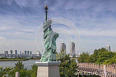 Replicas of the Statue of Liberty with cityscape background at Odaiba Park in Tokyo, Japan Stock Photo