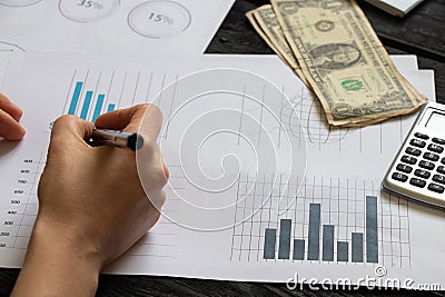 Reports and histograms on paper on the table in the hands of a girl, analytics and statistics on paper, business Stock Photo