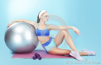 Repose. Sportswoman with Sport Equipment - a Fitness Ball and Dumbbells Stock Photo