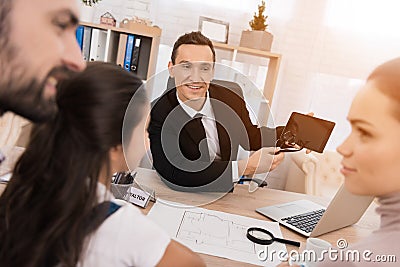 Representative realtor helps young family sell house. Concept of real estate sales. Stock Photo