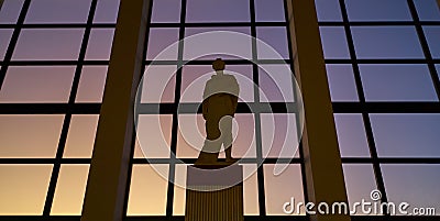 Reproduction Roman statue located in a large window with a sunset Stock Photo