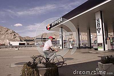 Repsol Petrol station with senior cyclist crossing Editorial Stock Photo