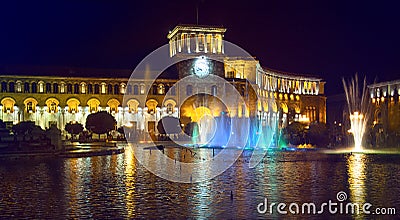 Republic Square at night in Yerevan. Clock tower. A fountain with colored lights and a building illuminated by lights. Stock Photo