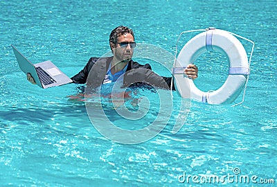 Rescue business. Business man in suit hold laptop and rescue lifebuoy in swim pool. Rescue swimming ring for businessman Stock Photo