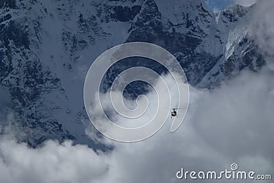 Rescue helicopter over big clouds, Gorak Shep, Everest Base Camp trek, Nepal Stock Photo