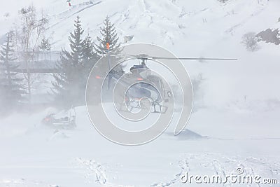 Rescue helicopter during a snow storm in the mountains Stock Photo