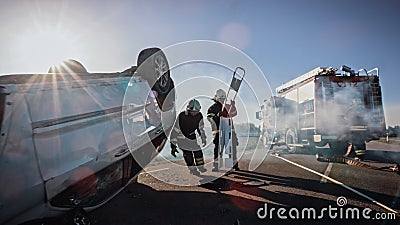 Rescue Team of Firefighters Arrive on Car Crash Traffic Accident Scene on their Fire Engine. Firem Stock Photo