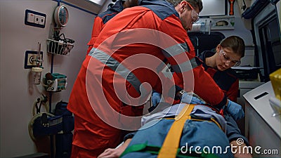 Rescue team of paramedics giving first aid help to victim in emergency car Stock Photo