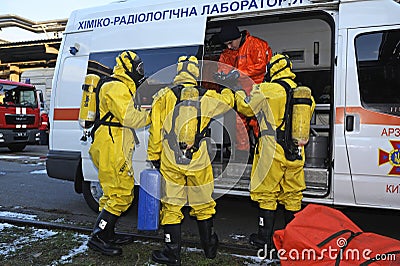 Rescue team training of chemical decontamination: rescuers in protective ensembles preparing equipment Editorial Stock Photo