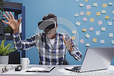 Research agency amazed surprised employee playing with VR technology while in office space. Stock Photo