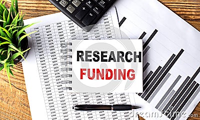 RESEARCH FUNDING text on a notebook with chart and calculator Stock Photo