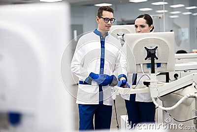 Research scientists using automated immunoassay system in lab Stock Photo