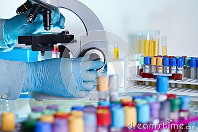 Researcher examining a sample under a microscope in the laboratory workbench Stock Photo