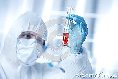 Researcher in hazmat suit with test tube Stock Photo