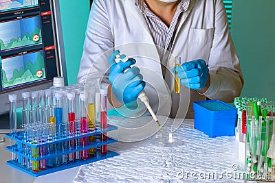 Researcher pipetting sample in tube in the science lab Stock Photo