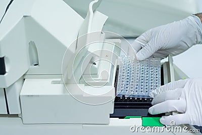 Researcher or scientific introducing a 96 wells plate in quantitative PCR machine Stock Photo