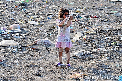 RESEN, MACEDONIA - JULY 23 : Unidentified child is looking at magazine paper in a garbage dump Editorial Stock Photo