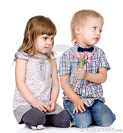 Resentful boy gives to the girl a flower. isolated on white back Stock Photo