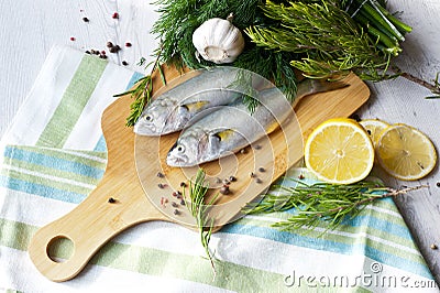 Resh fish with the vegetables, condiment and lemon, bluefish. Food preparation. Stock Photo