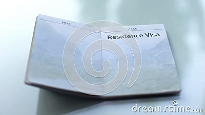 Residence visa, opened passport lying on table in customs office, travelling Stock Photo
