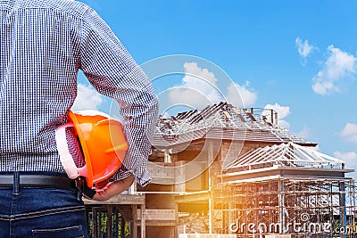 Resident engineer holding yellow safety helmet at new home building Stock Photo