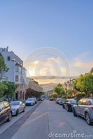 Residential area with roadside parking space and a view of sunset sky in San Francisco, CA Stock Photo