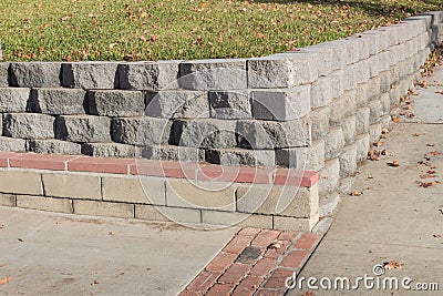 Residential retaining wall featuring a variety of stacked blocks and mortared brick textures Stock Photo