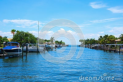 Residential saltwater canal in south Florida with blue water and many boats docks and palm trees Stock Photo