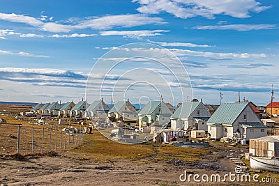 Residential wooden houses on a dirt road next to the airport in Pond Inlet, Baffin Island, Canada. Editorial Stock Photo